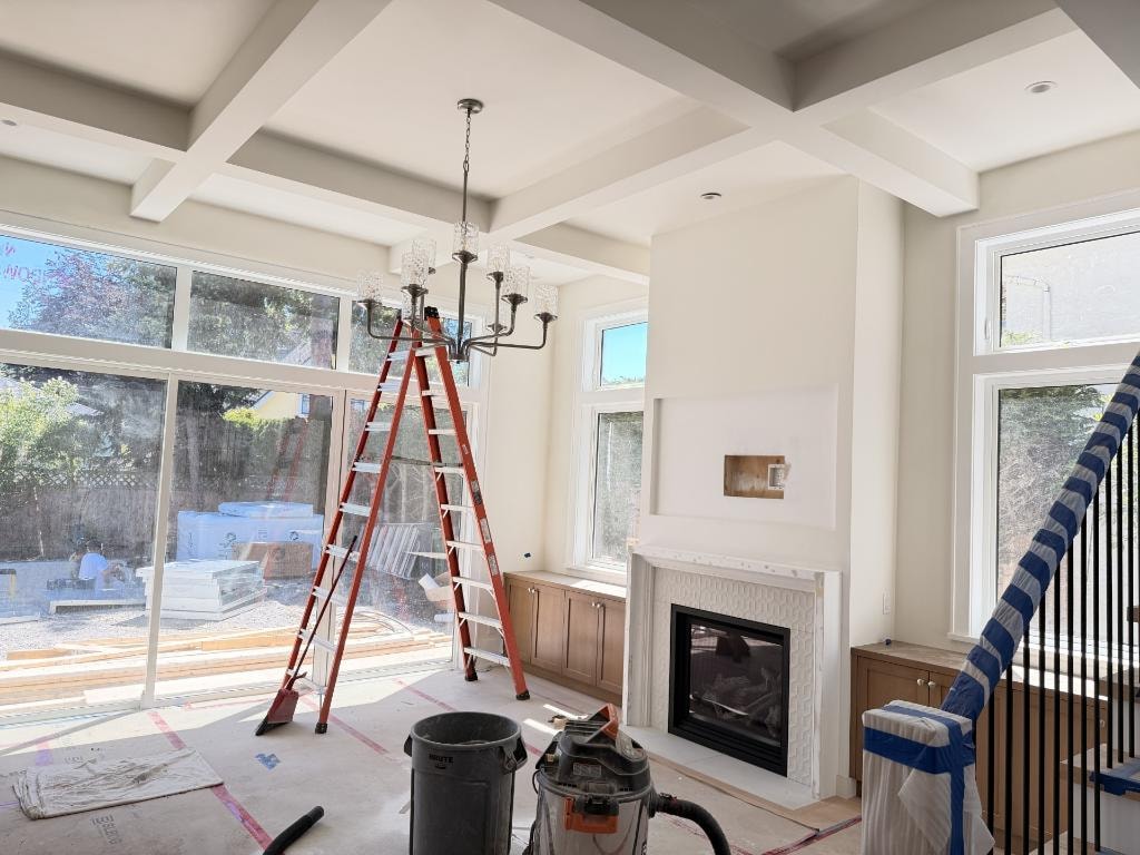 Luxury home interior under construction with coffered ceilings and fireplace